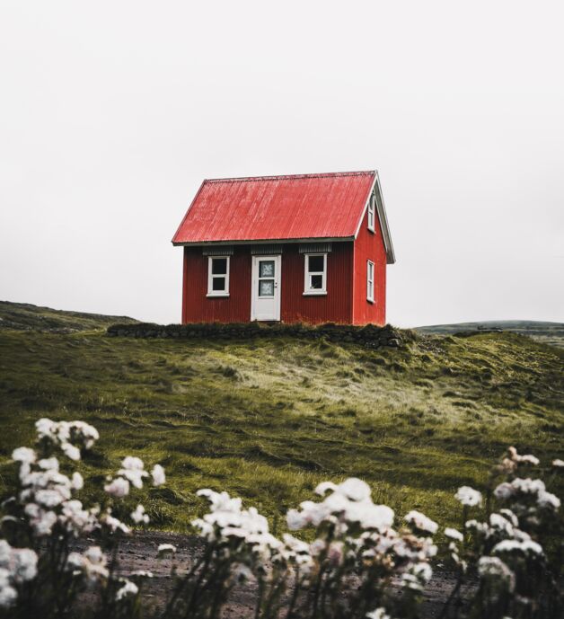 Photography by Luke Stackpoole - a red house on a green meadow